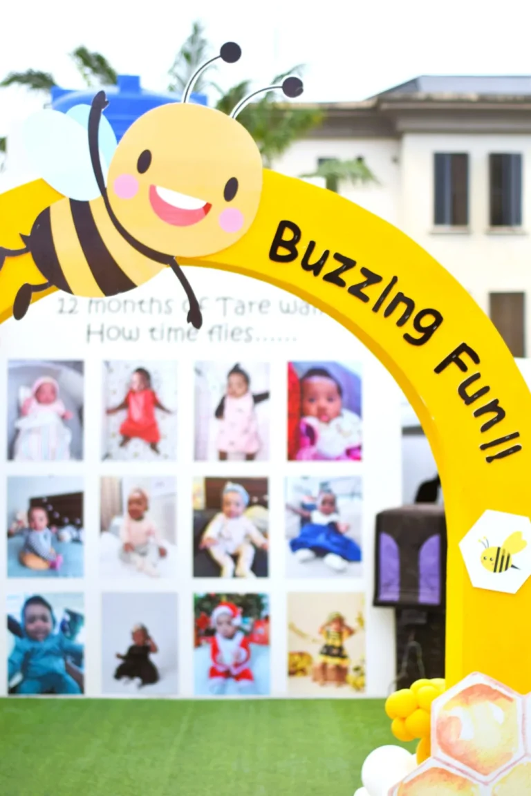 A yellow bee-shaped arch frames a photo collage celebrating twelve months of a baby.